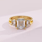 Gold ring with a large diamond and smaller diamonds on a light pink background
