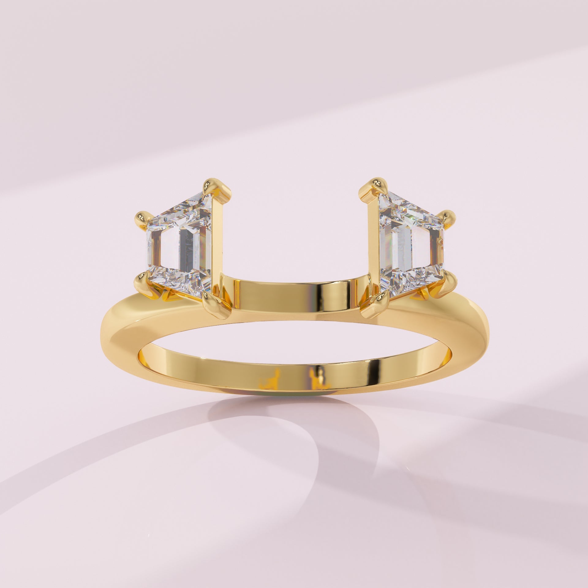 Gold ring with two emerald-cut diamonds on a light pink background