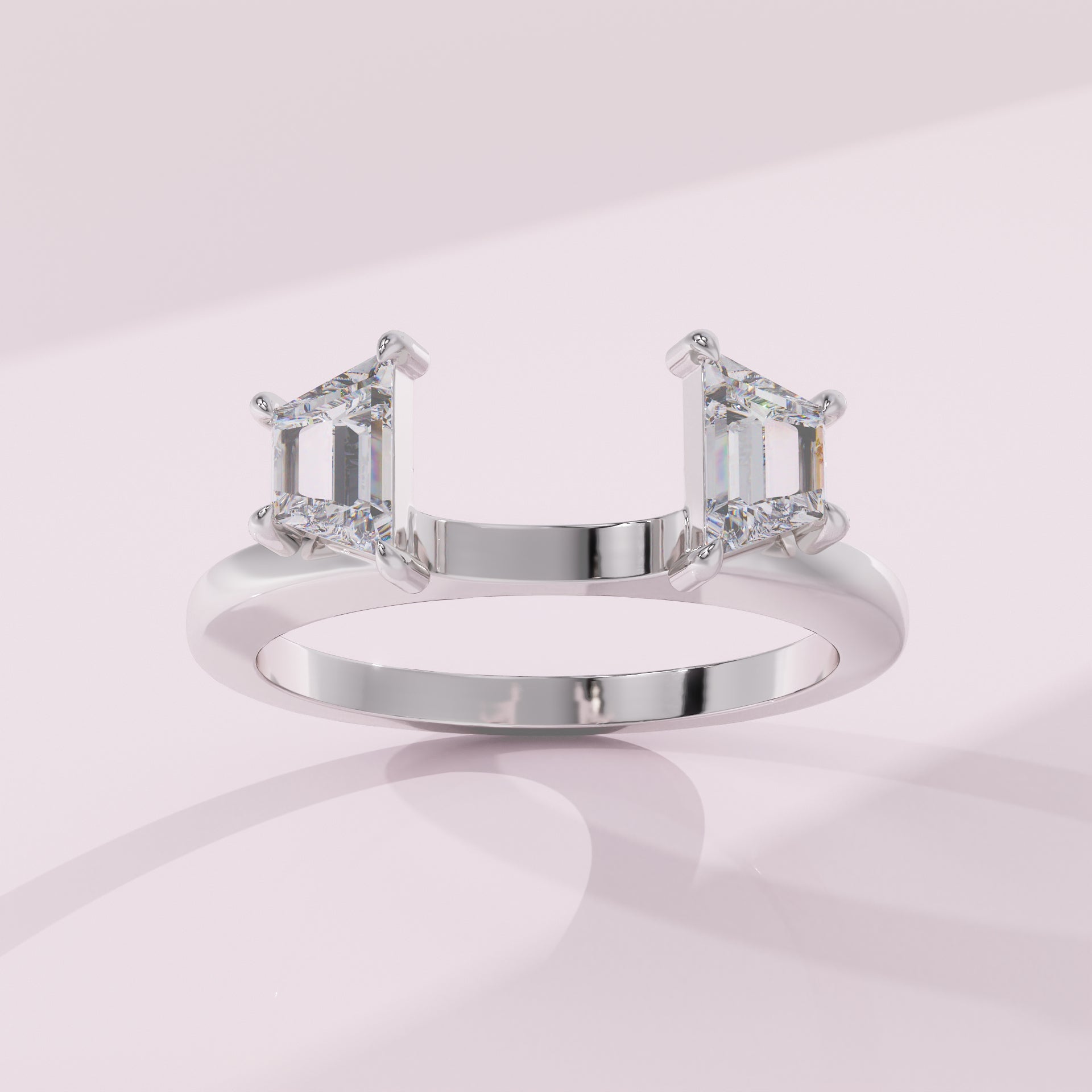 Silver ring with emerald-cut diamonds on a light pink background