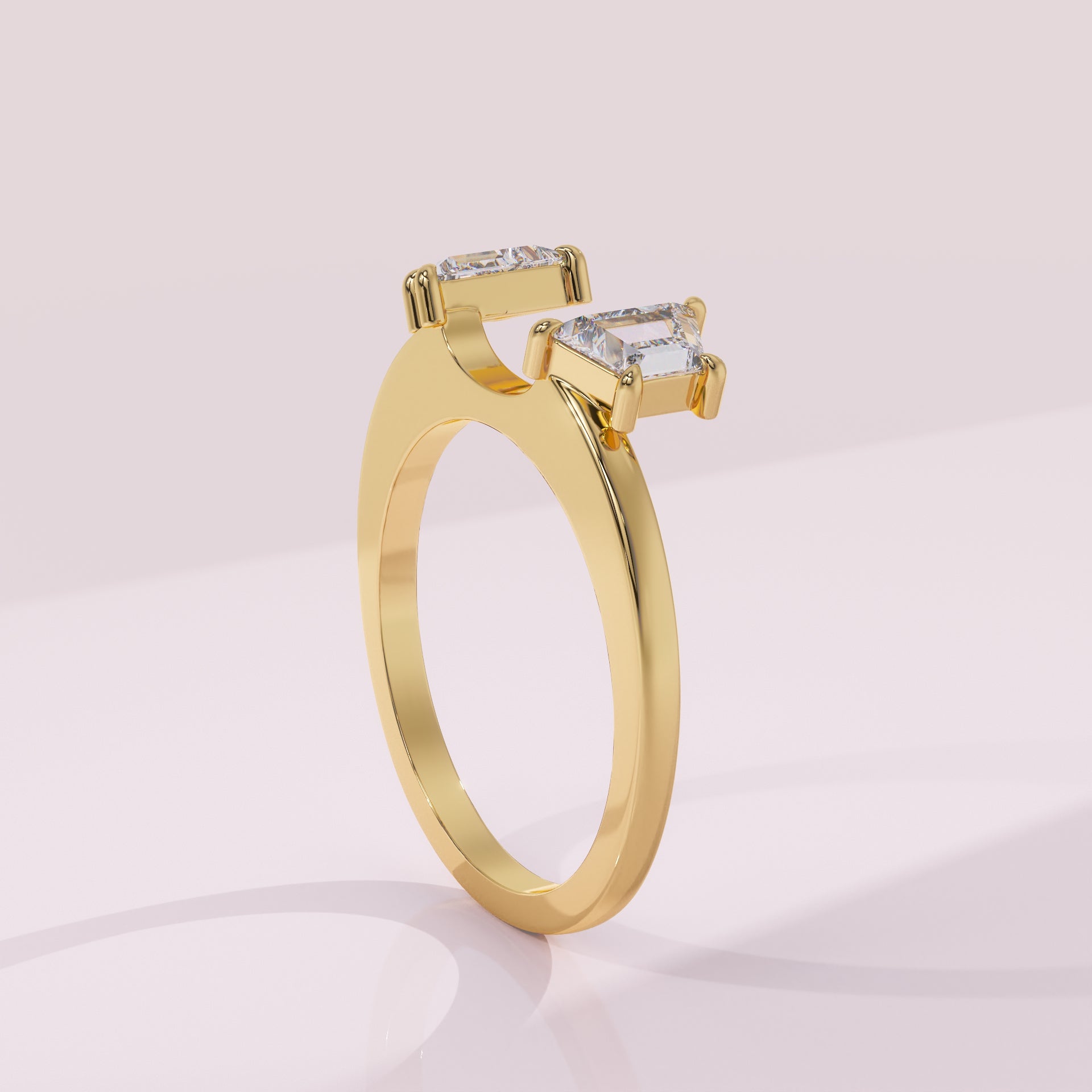 Gold ring with two square-cut diamonds on a light pink background