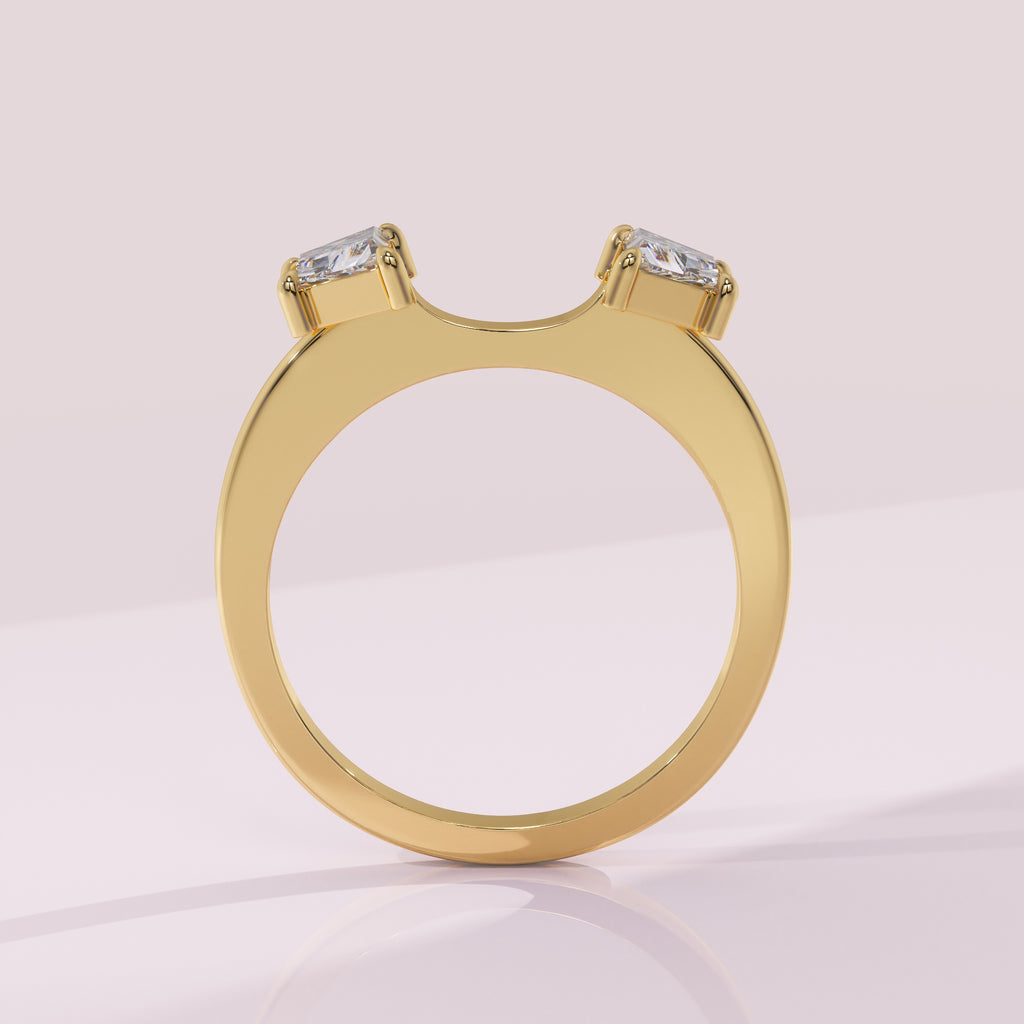 Gold ring with two diamond stones on a light pink background