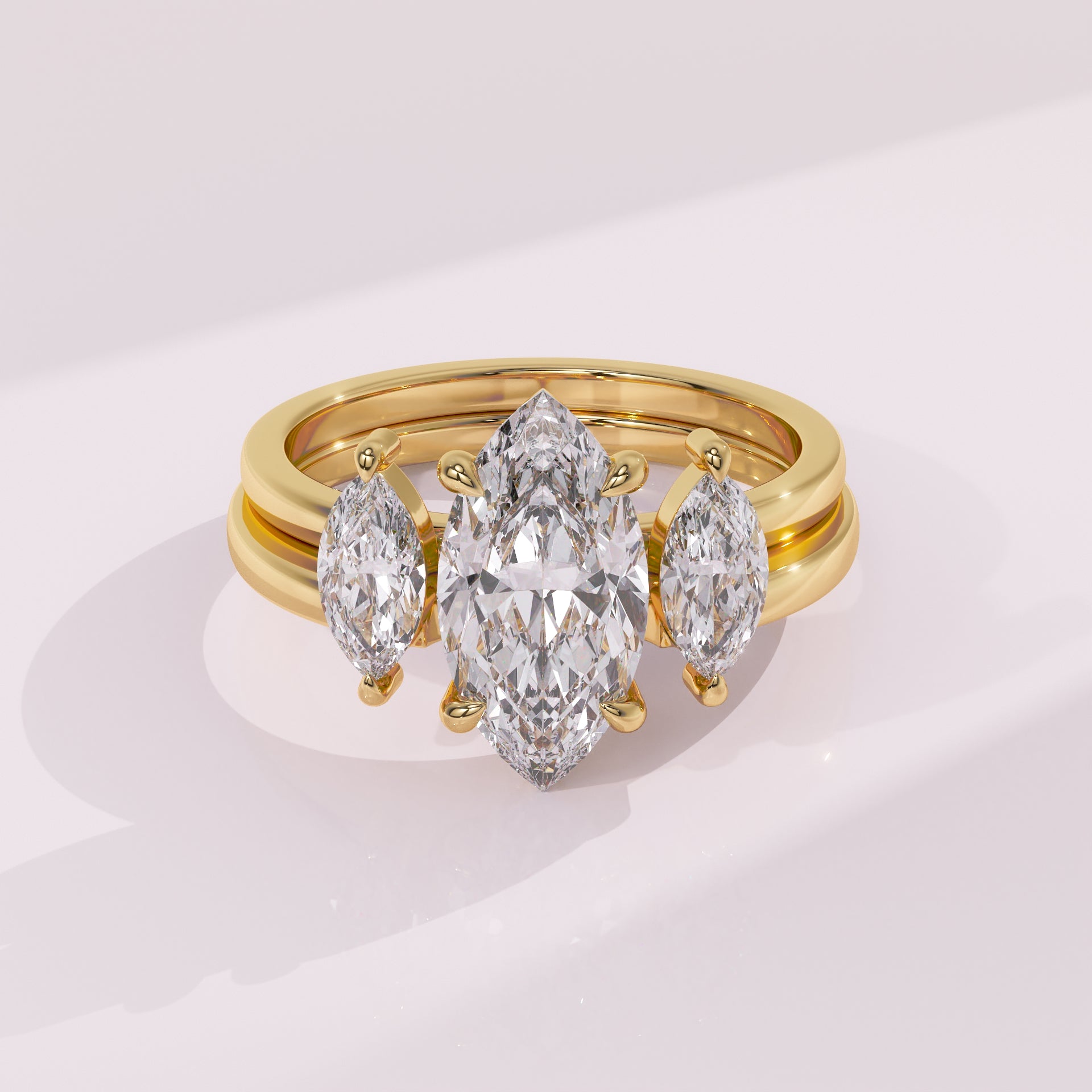 Gold ring with three pear-shaped diamonds on a light pink background