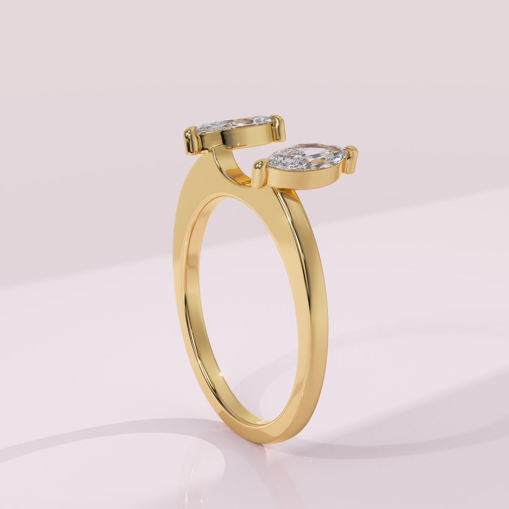 Gold ring with two diamond-like stones on a light pink background