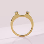 Gold ring with two small diamonds on a light pink background