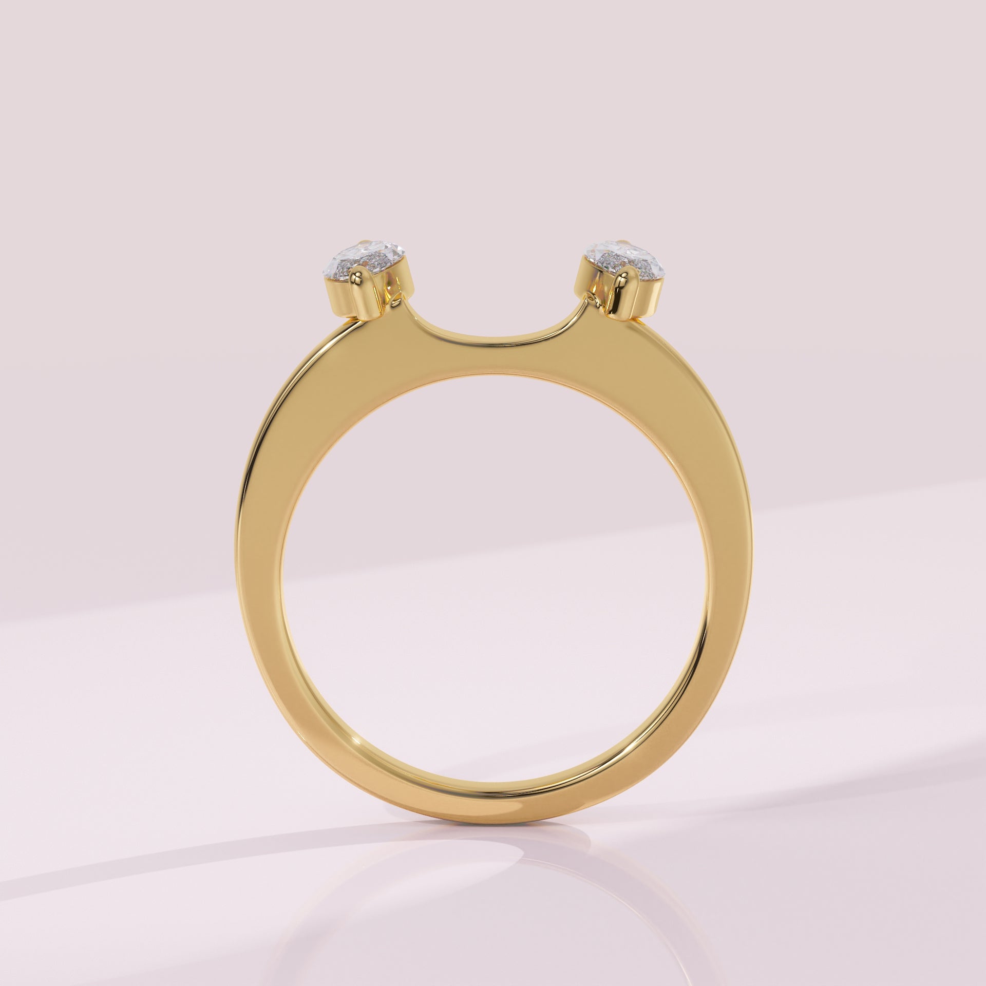 Gold ring with two small diamonds on a light pink background